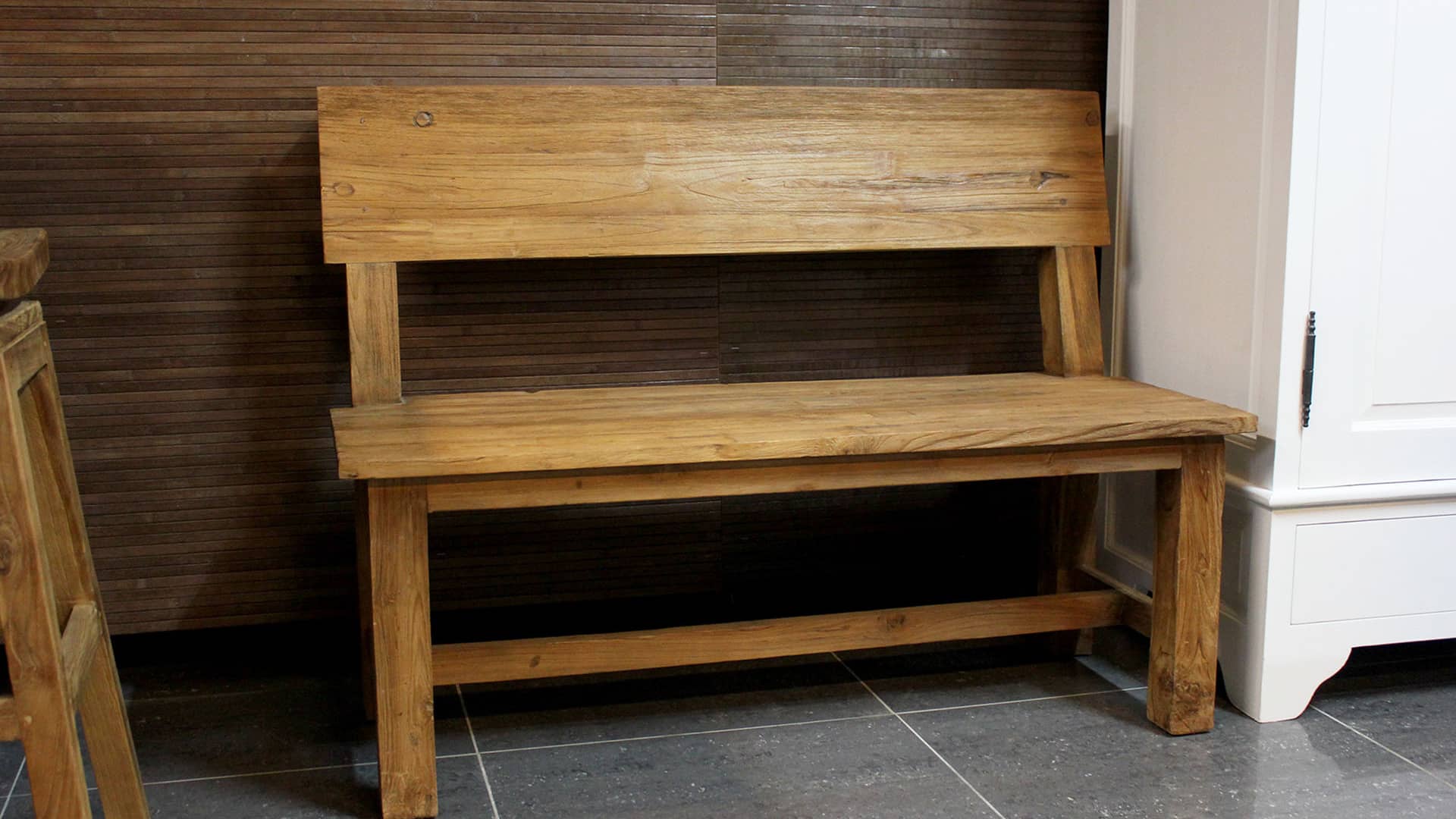 Landelijke houten bank in massief teak voor aan de eettafel.