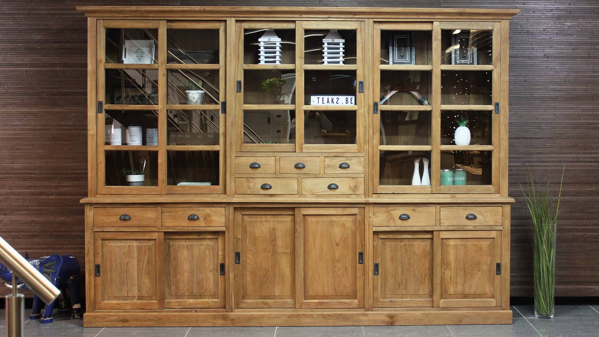 Landelijke vitrinekast teakhout met schuifdeuren en lades.